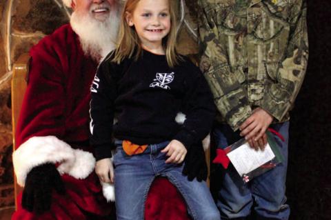 Evvy and Eli Sallee promise Santa (Bill Cagle) they have been good all year.