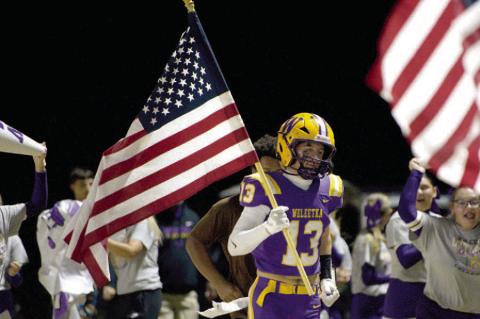 Bryant Sites carries out “Old Glory” before the game against Shattuck.