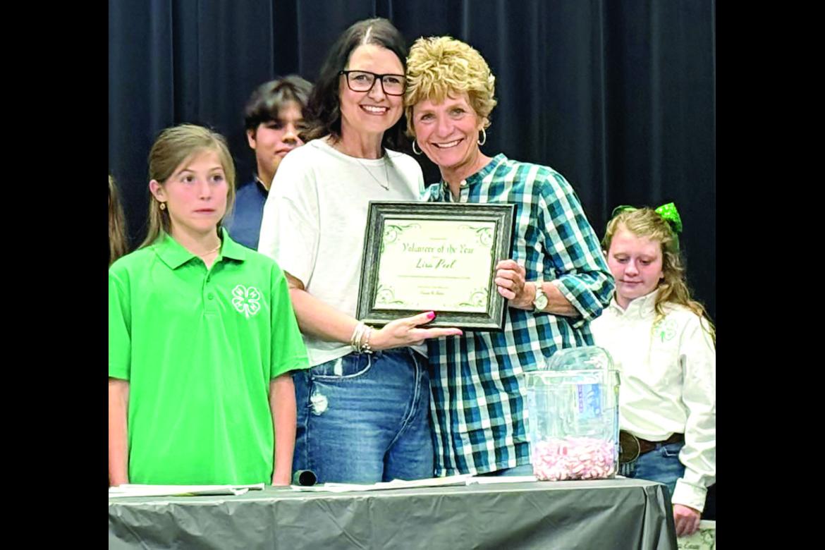 4-H leader Kassie Ingle presenting Lisa Peel with the “4-H Volunteer of the Year” award.